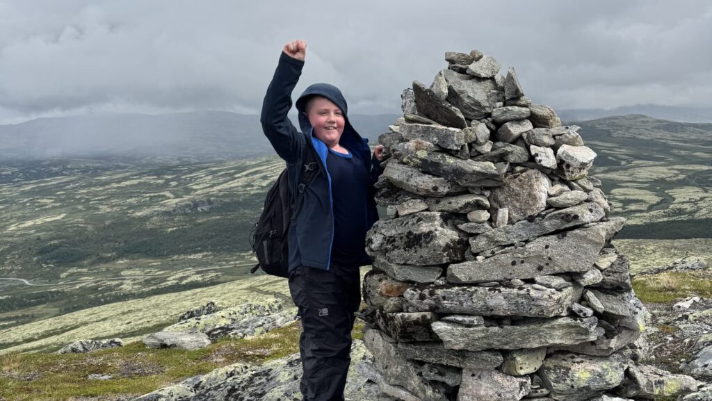 Child with rock collection on hiking trip in Norway